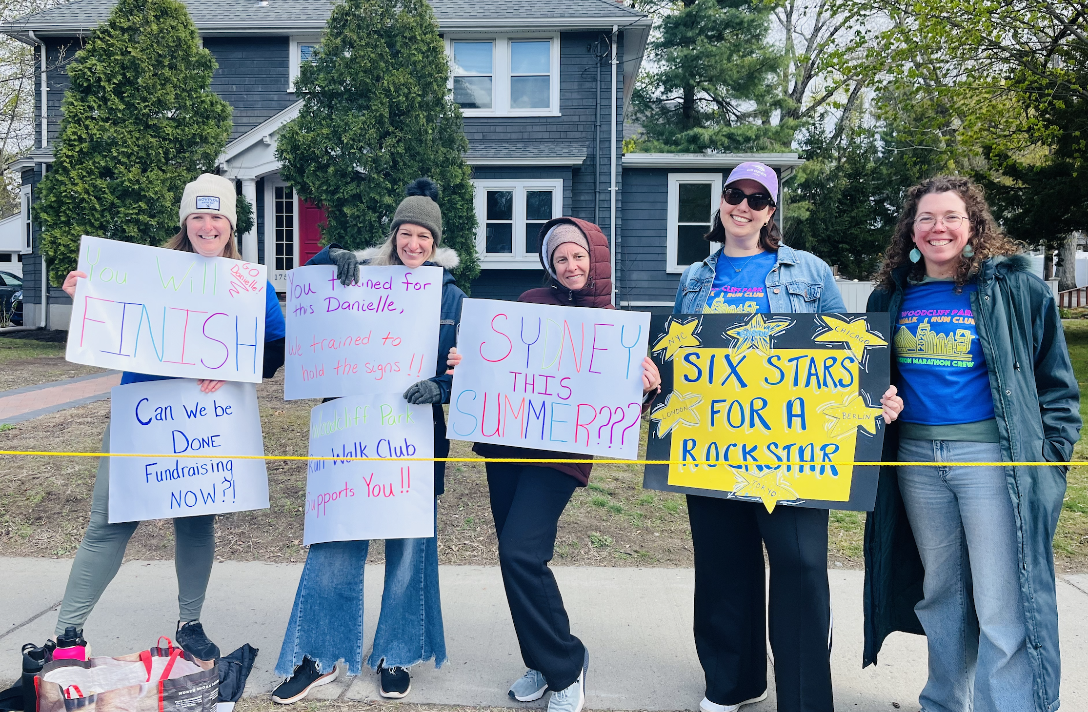 Supporters from Woodcliff Walk Run Club holding signs and cheering
